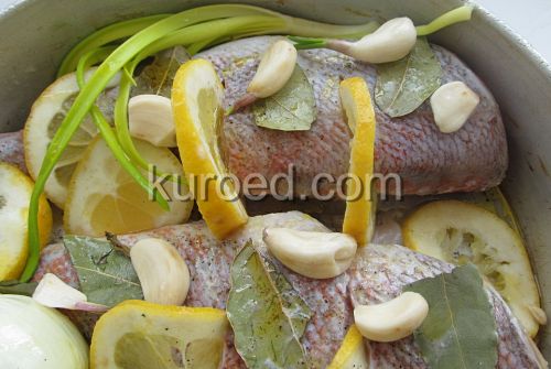 Морской окунь запеченный с лимоном, пошаговое приготовление - выложить лавровые листья и зубчики чеснока